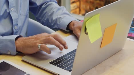 Man-using-laptop-in-a-creative-office