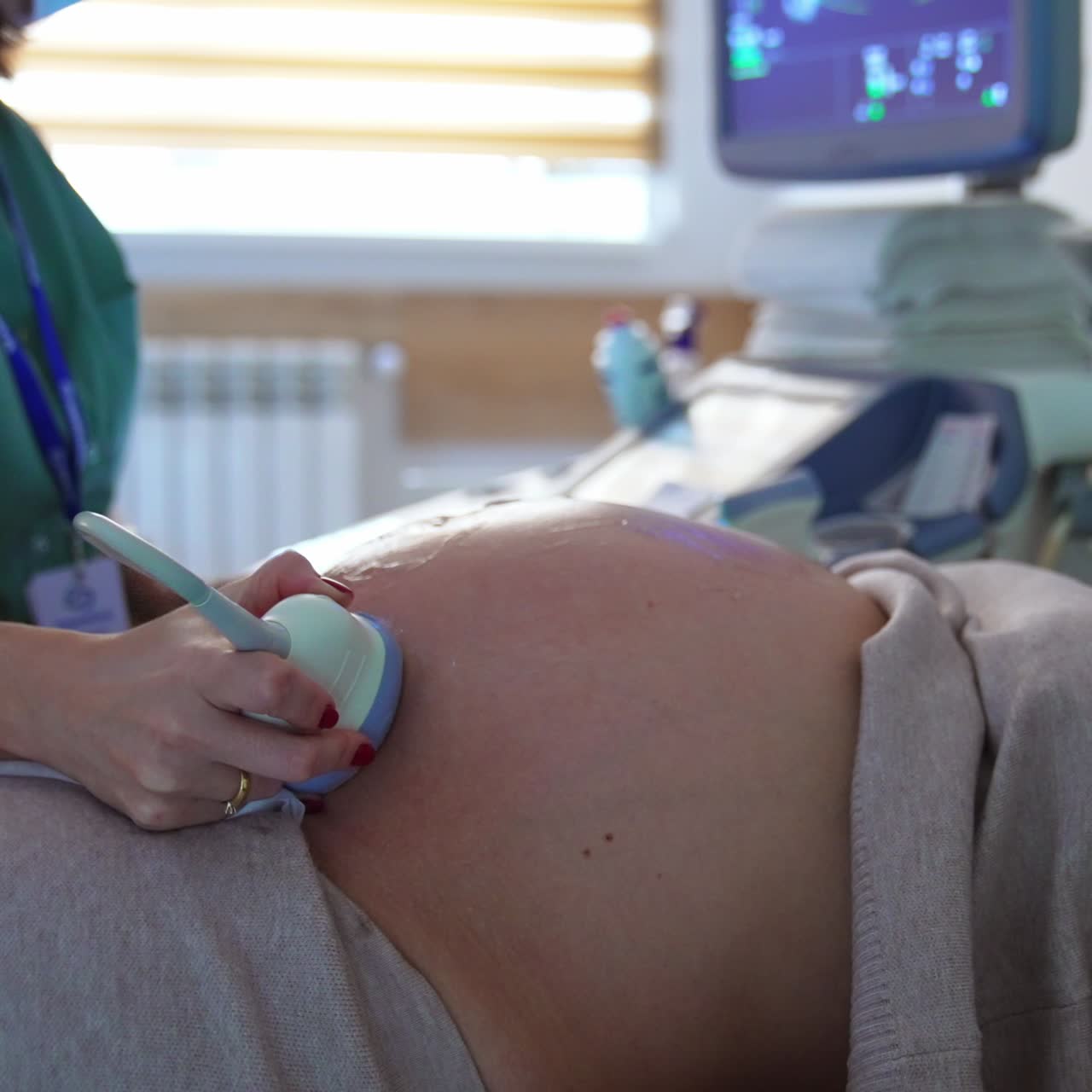Donna incinta con il pancione è al controllo dall'ostetrico. Il medico sta eseguendo un'ecografia alla futura mamma.