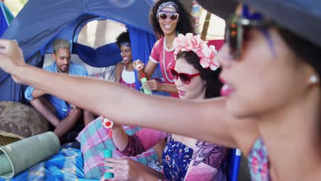 group of friends playing with bubbles at music festival 4k