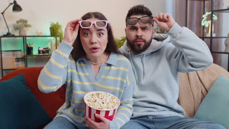 Family man woman on couch eating popcorn watching interesting tv serial sport game online at home