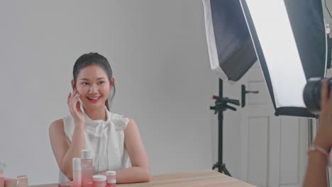 behind the scenes on photo shoot: beautiful asian model poses for a photographer