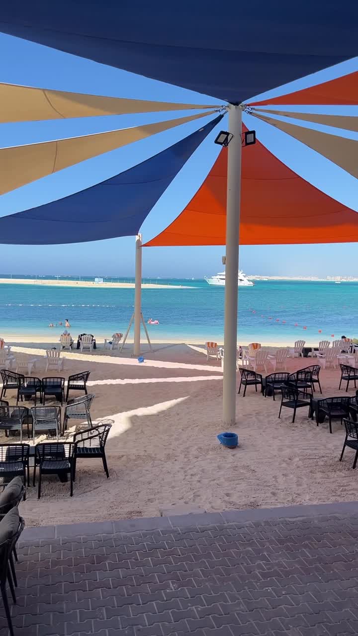 A view of a beach full of chairs and umbrellas, close up shot, wide shot