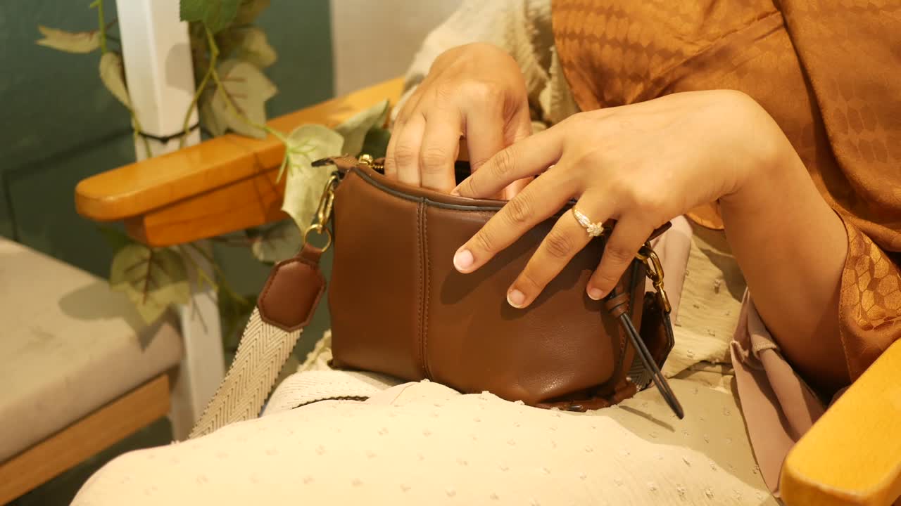 Donna che tira fuori qualcosa da una borsa marrone