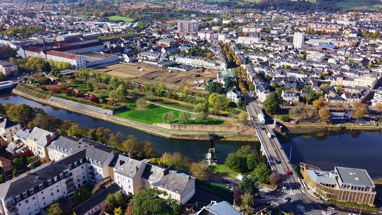 Drone panning cityscape showing European Le Mans town with Sarthe River bends and dense residential blocks, France