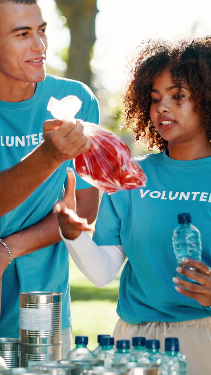 Jovens Voluntários Distribuindo Comida e Água em um Evento Beneficente ao Ar Livre
