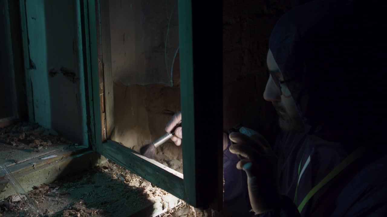 vista detallada del investigador de ciencias forenses, cepillado del marco de la ventana vieja, búsqueda de evidencia de la escena del crimen