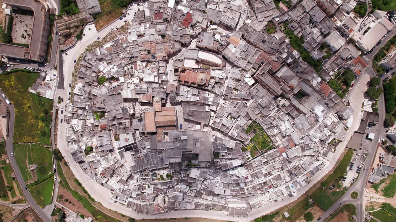 Aerial bird's eye rising view of white italian town Ostuni, Puglia, Italy