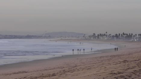 people walking on cold winter beach during high tide