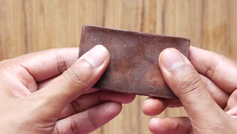 hands holding a piece of brown clay