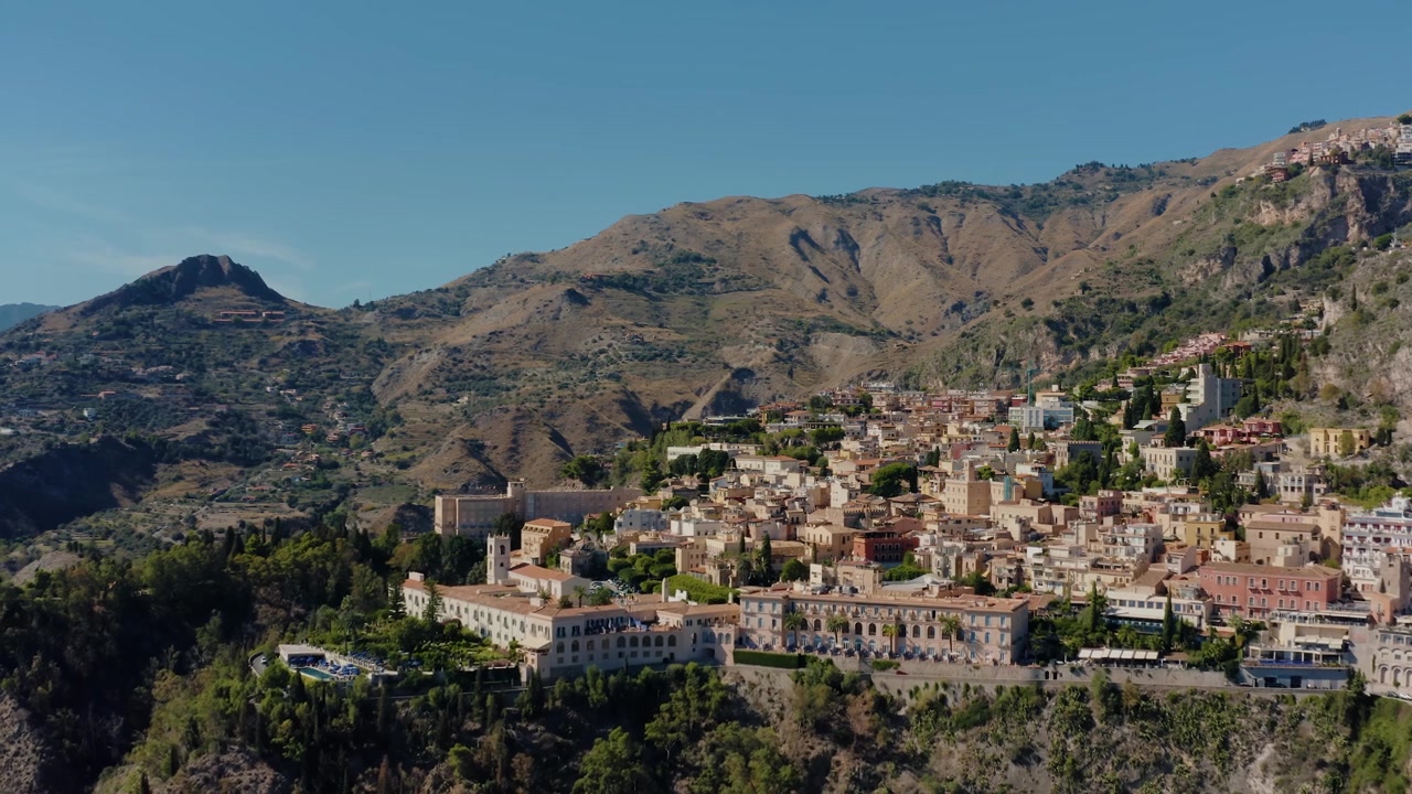 Droneoptagelse fra luften, der flyver mod den gamle by Taormina på Sicilien. Spektakulær udsigt over den italienske landsby på toppen af bjergene. Mest populære rejsedestination på Sicilien.