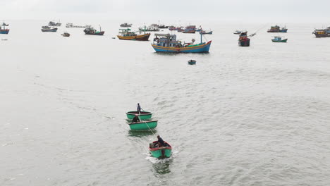 local vietnam fisherman pulling small boats through waves, aerial view