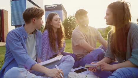grupo de estudiantes caucásicos que estudian fuera del campus universitario