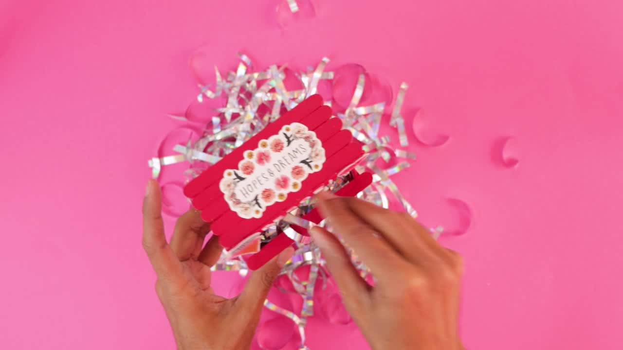 Filling miniature Valentines day kissing booth with silver confetti