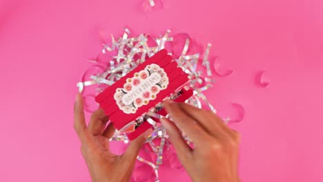 filling miniature valentines day kissing booth with silver confetti