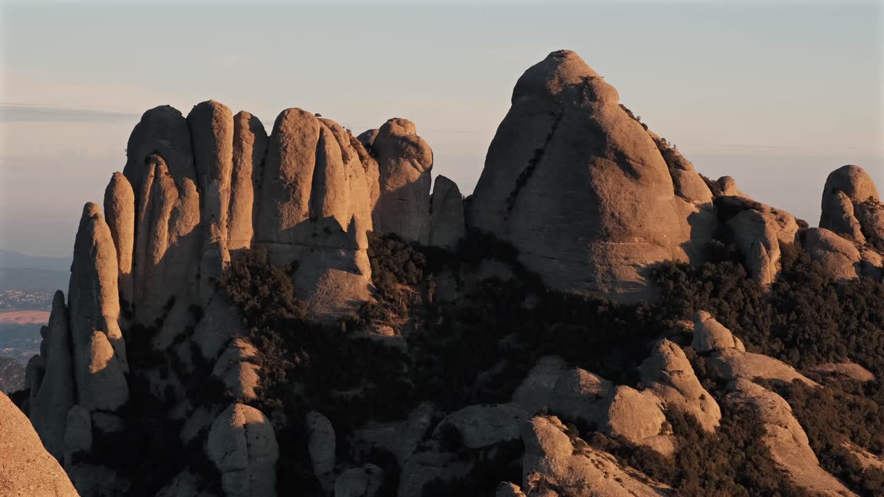 Stunning 4K still shot of Montserrat’s rocky peaks bathed in warm sunset light. Perfect for nature lovers and landscape collectors