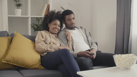 young couple having fun while watching tv 1