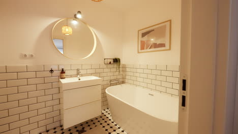 revealing shot of a small minimalist bathroom with white titled accents