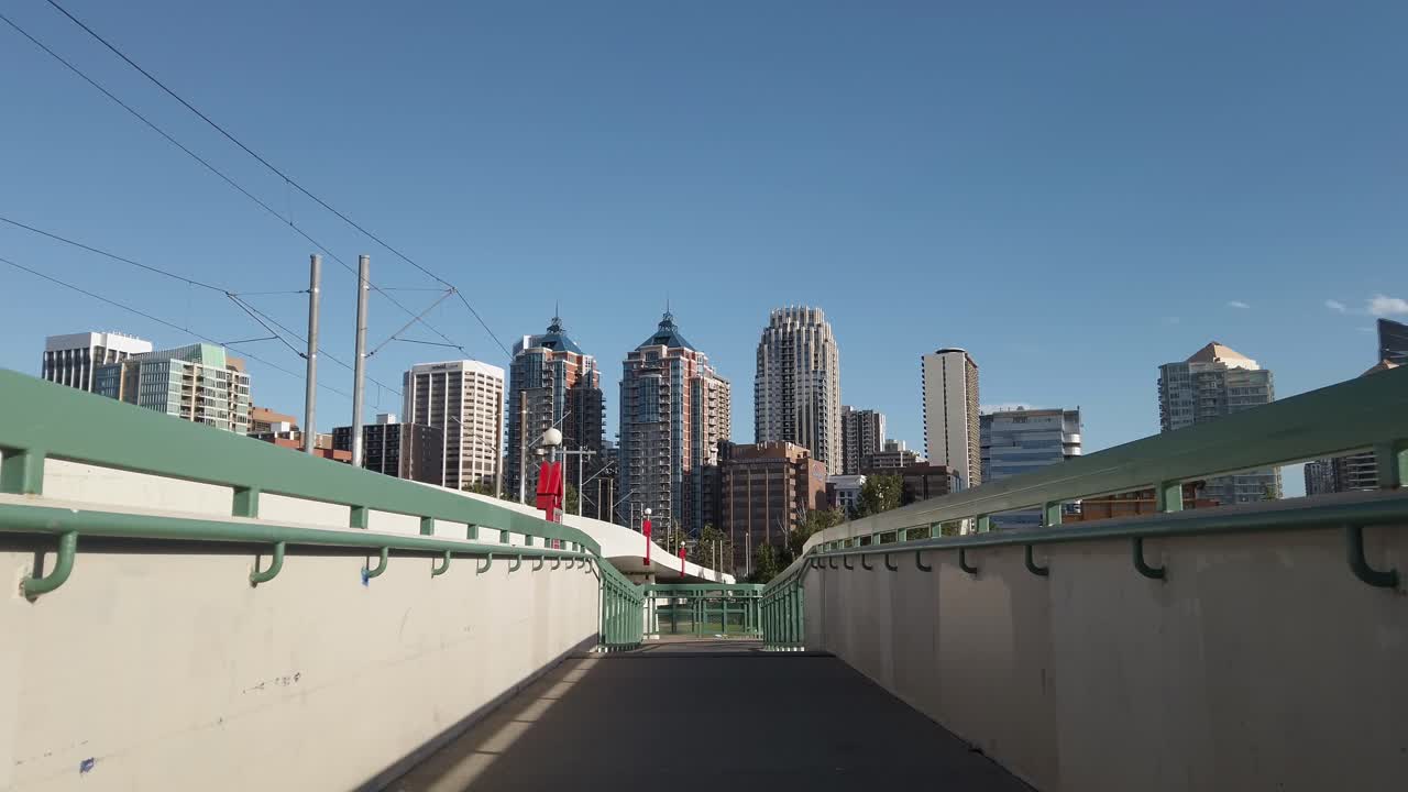 rascacielos de la ciudad se acercaron desde un puente peatonal en un día soleado ángulo bajo calgary alberta canadá