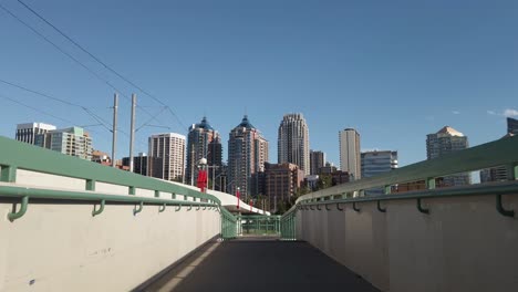 City-skyscrapers-approached-from-a-pedestrian-bridge-on-a-sunny-day-low-angle-Calgary-Alberta-Canada