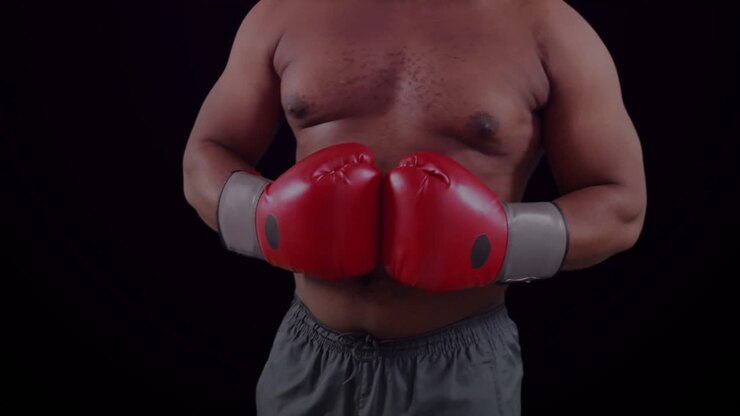 Pugile che stringe i guanti, scintilla viola che divampa trasformandosi in una rete VFX sul petto, in preparazione di un incontro sportivo