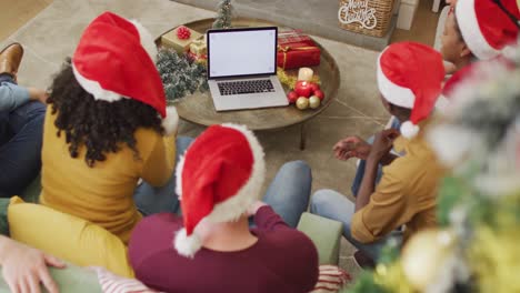 Happy-diverse-friends-in-santa-hats-making-christmas-laptop-video-call,-copy-space-on-screen