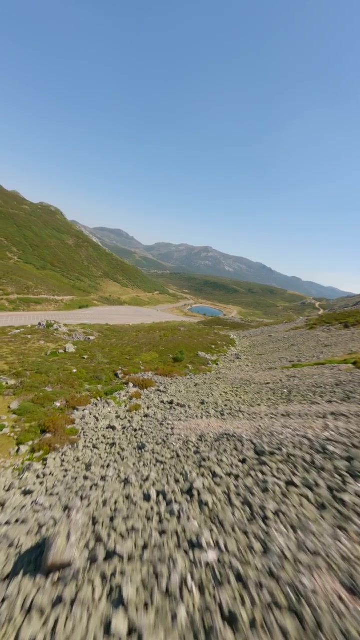 Video verticale dinamico con riprese aeree da drone FPV che sorvola pendii rocciosi e valli lussureggianti a Puerto San Isidro, Asturie. Cattura cieli sereni e un paesaggio vibrante.