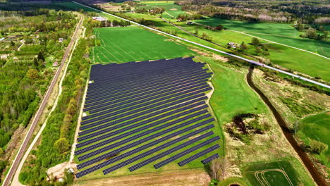 solar panels on farmland, aerial view in spring with lush green surroundings