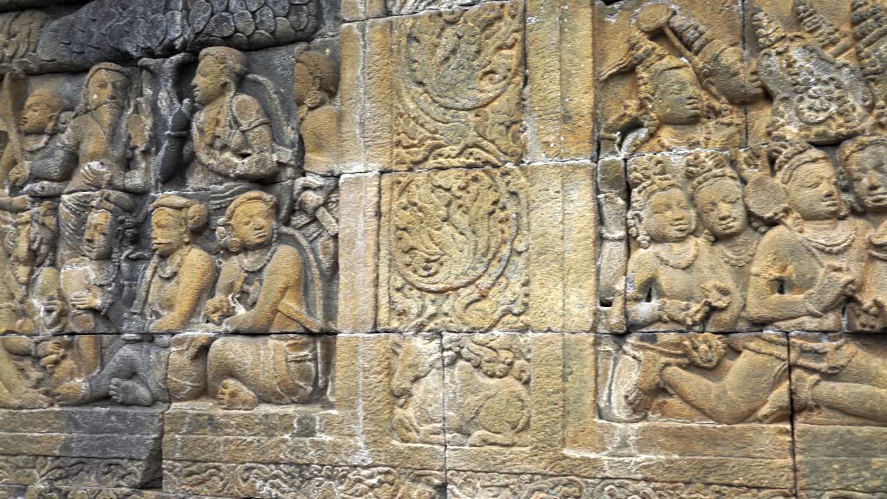 Indonesia,Jawa Island,Yogyakarta,Unesco world heritage Borobudur Temple's inside,wall relief close up.Camera slides slowly from left to right and shows the relief in details,ancient stories on wall.