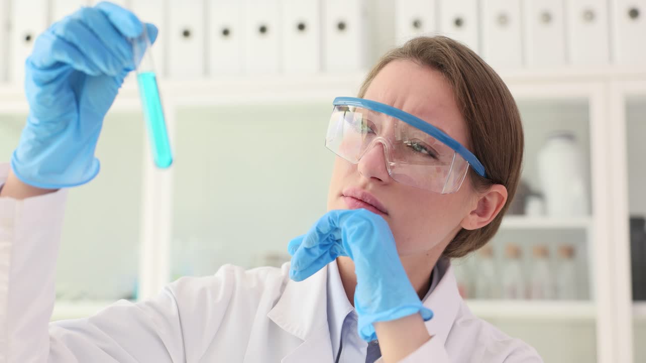 A female scientist examines a test tube in a laboratory