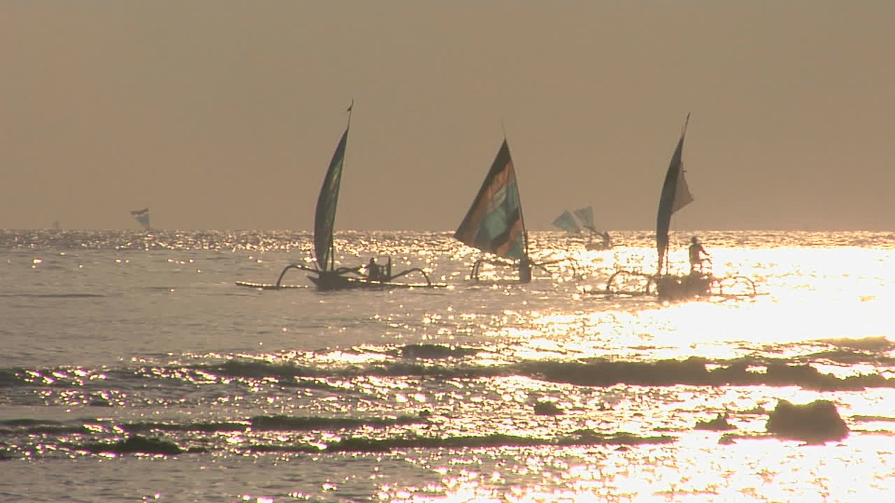 парусные лодки на берегу сверкающего моря