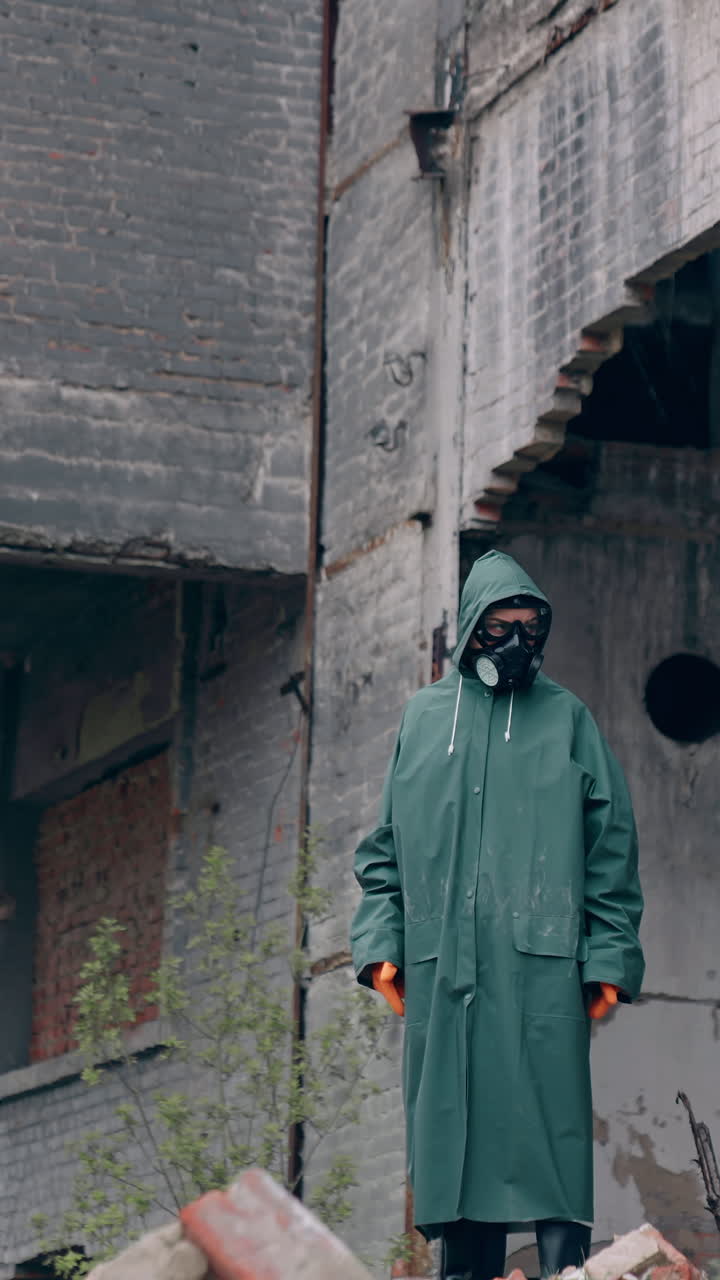 Save our planet. Motion camera view of the human wearing protective mask standing at the abandoned place. Environmental pollution, ecological disaster, nuclear war, post apocalypse concept. Vertical video