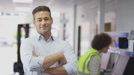 portrait of smiling male manager in busy logistics distribution warehouse