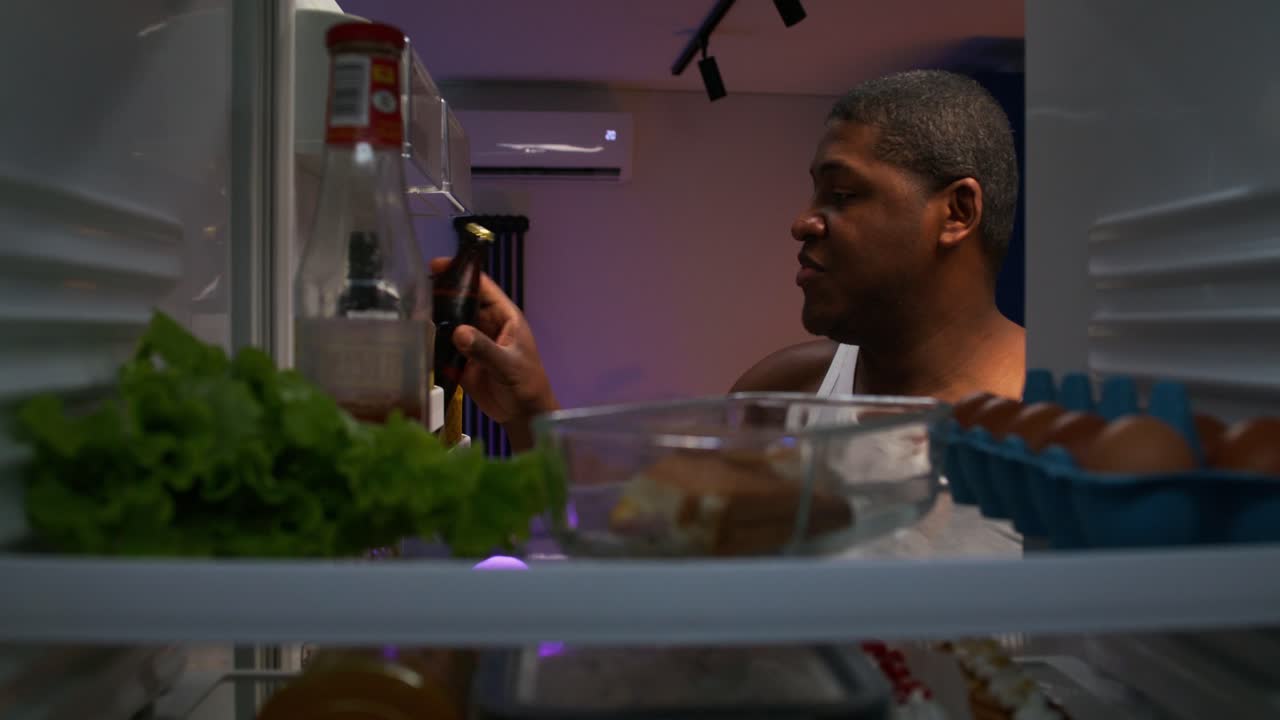 Man Drinking Beer from Refrigerator at Night
