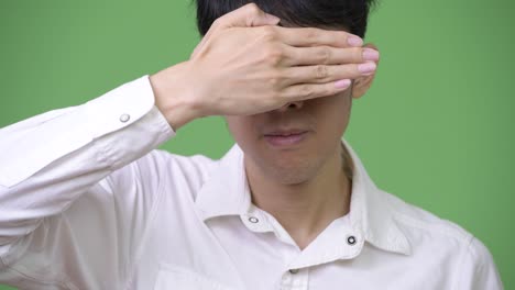 young asian businessman covering eyes as see no evil concept