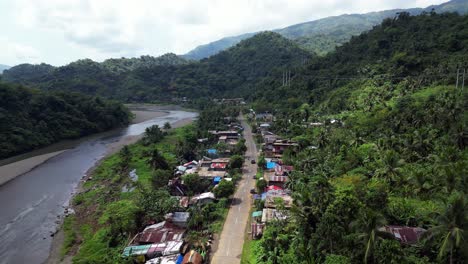 carretilla aérea a lo largo de una carretera tropical alineada con casas del sudeste asiático en filipinas