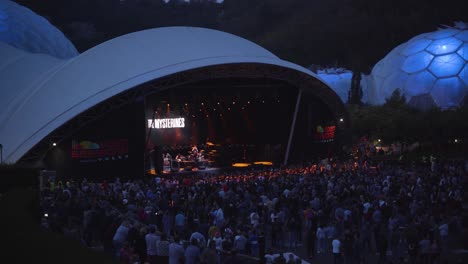 live band concert at eden project domes with spectators waiting for their show at night. - wide