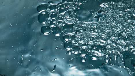 sparkling aqua bubbling inside container closeup. soda fizzy drink glass macro