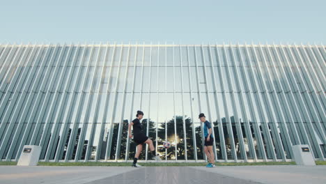 two female soccer athletes doing kick-ups with ball on street