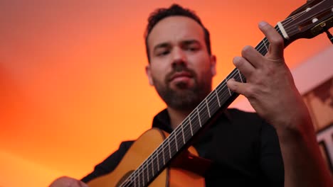 hombre barbudo tocando la canción en la guitarra