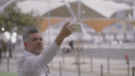 mature man taking selfie with mobile phone outdoor