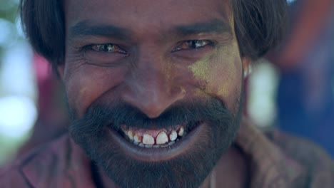 indian man close-up of face smeared with bright holi colors