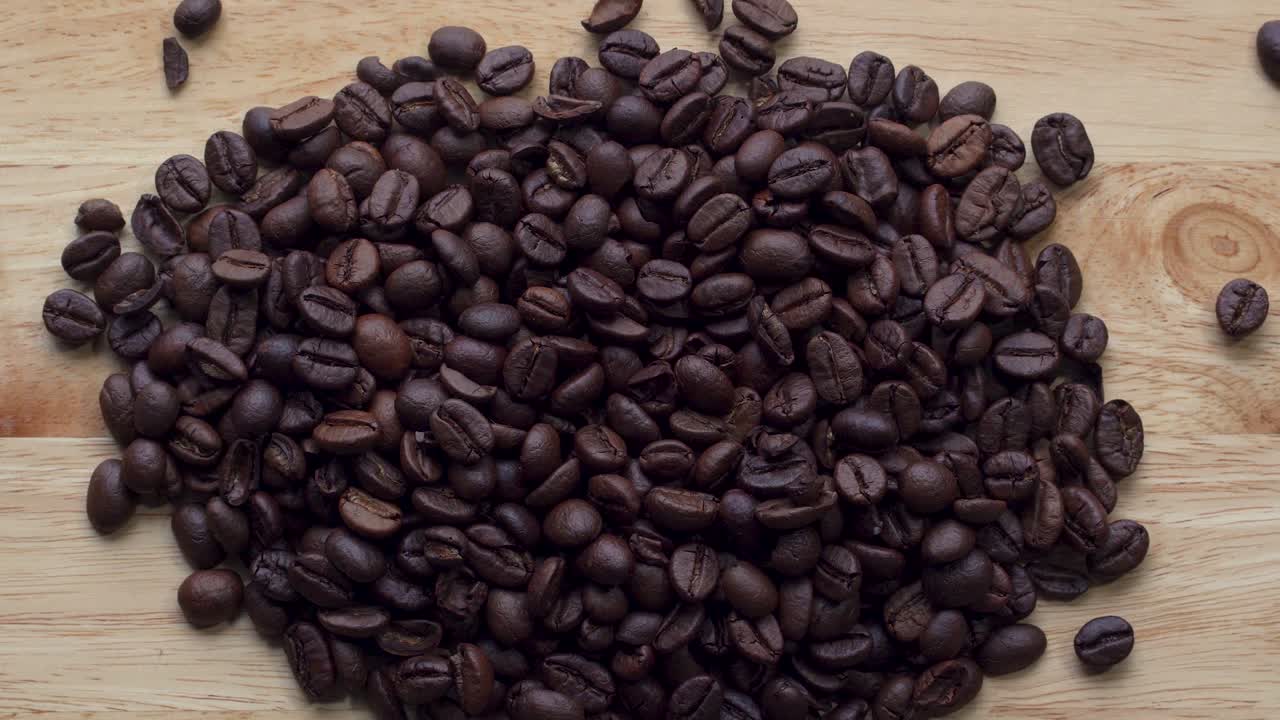 Filmato 4K. 4096x2304P. Chicchi di caffè profumati tostati in padella, con fumo che sale. L'intera composizione ruota lentamente intorno alla telecamera. Mescolare i chicchi di caffè.