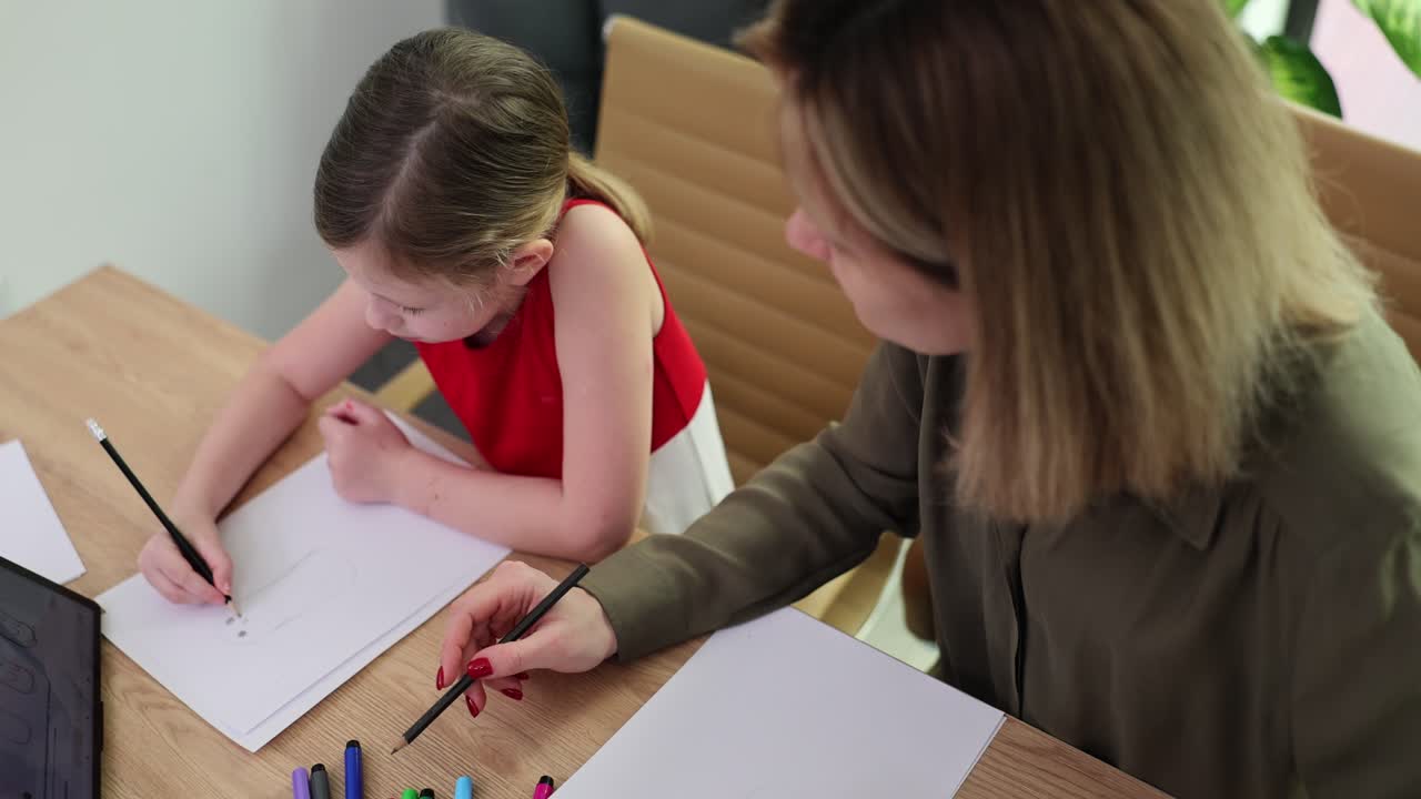 Woman and Child Drawing Together at Table
