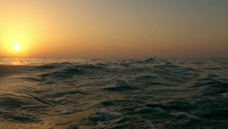 Puesta-De-Sol-Romántica-Sobre-El-Agua-De-Mar,-Superficie-De-Agua-De-Mar-De-ángulo-Bajo-Fpv-Pov-Moviéndose-Hacia-Atrás-En-Cámara-Lenta