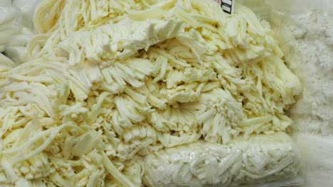 large pile of shredded cheese at a market