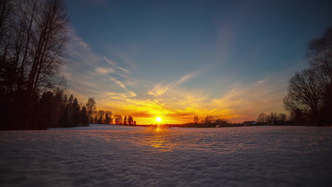 nevado, timelapse del paisaje invernal y el sol naranja en el horizonte, con las nubes avanzando
