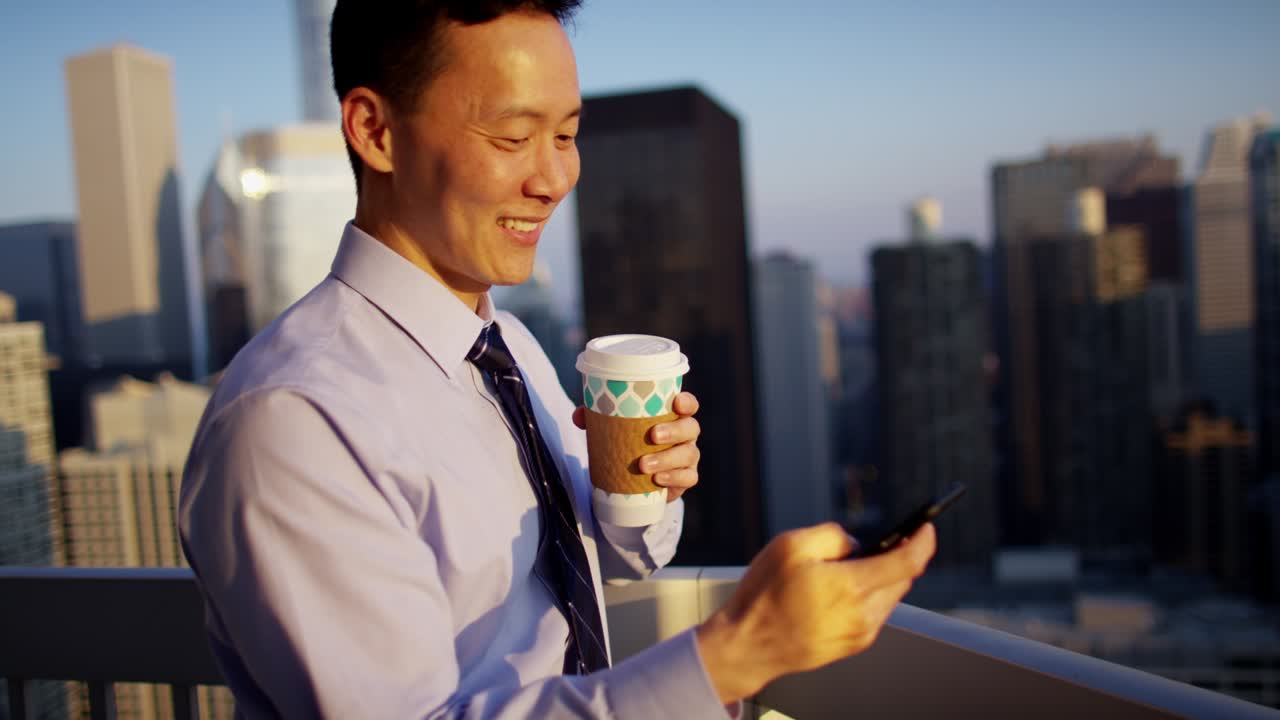 해가 뜨는 지붕에서 스마트폰을 사용하는 민족 사업가