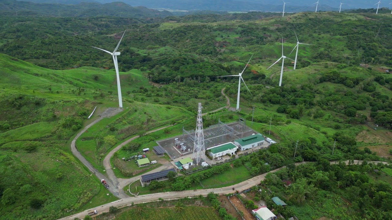 Power plant. Aerial drone cinematography of wind turbines at Pililla Wind Farm with dramatic mountain landscapes and tropical vegetation across Rizal.