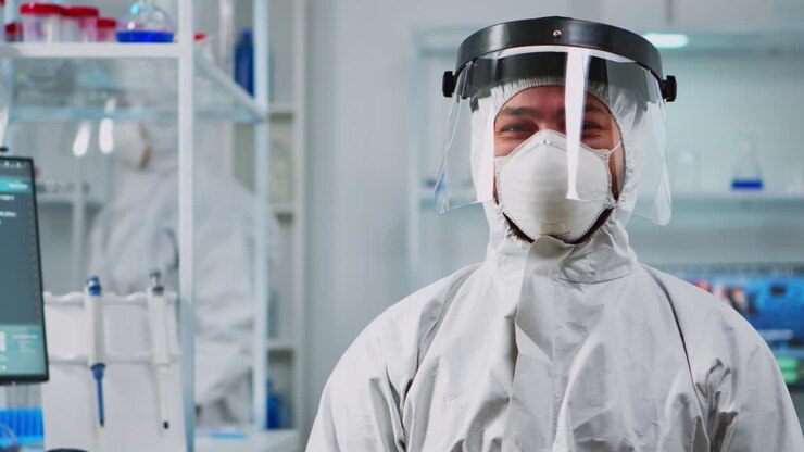 Scientist man wearing coverall smiling at camera