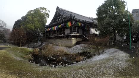 traditional japanese building with snow falling